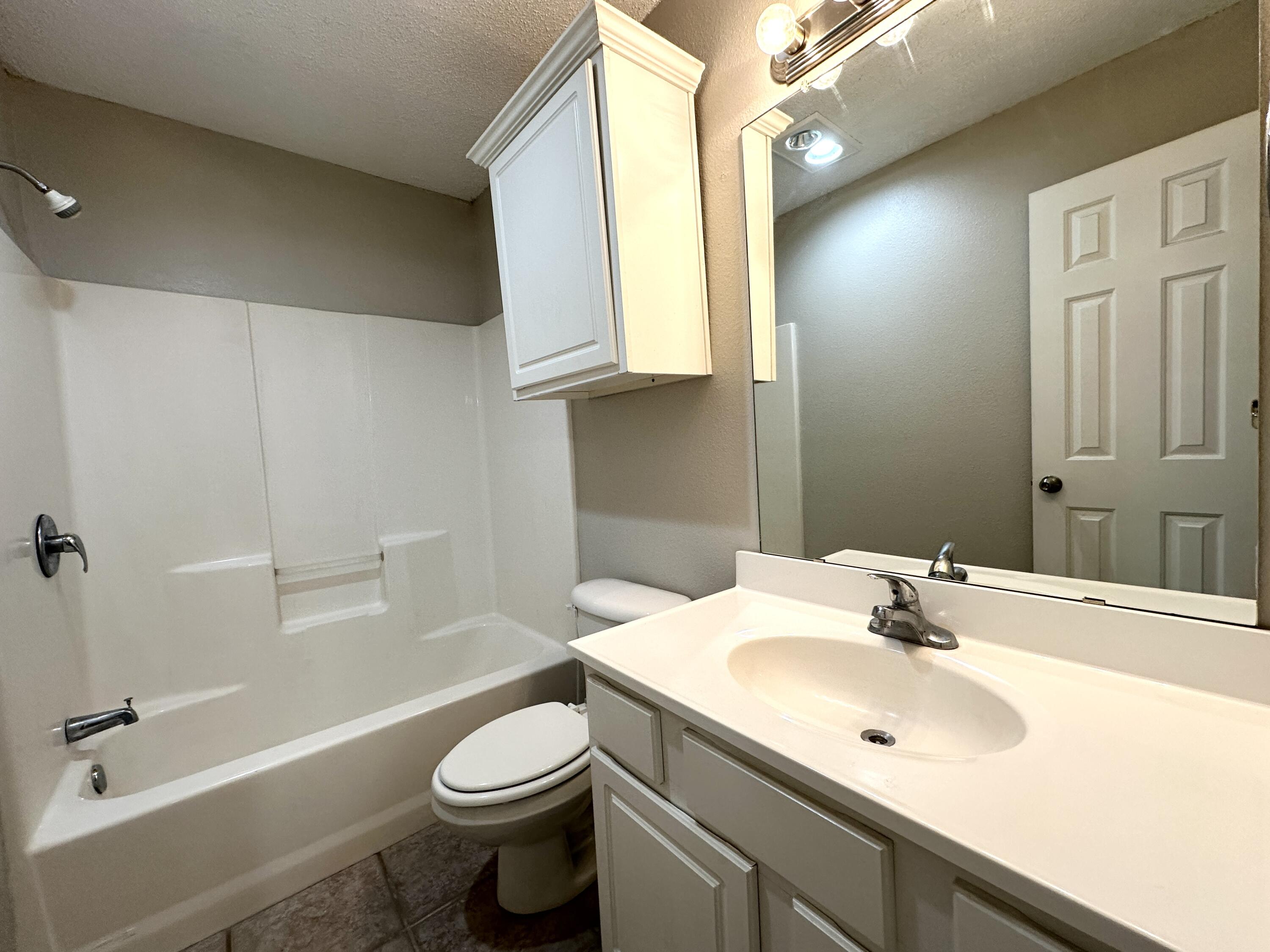 615 North Elkhart Avenue Lubbock, TX 79416 - Photo 6 of 15 a bathroom with a sink a toilet and shower