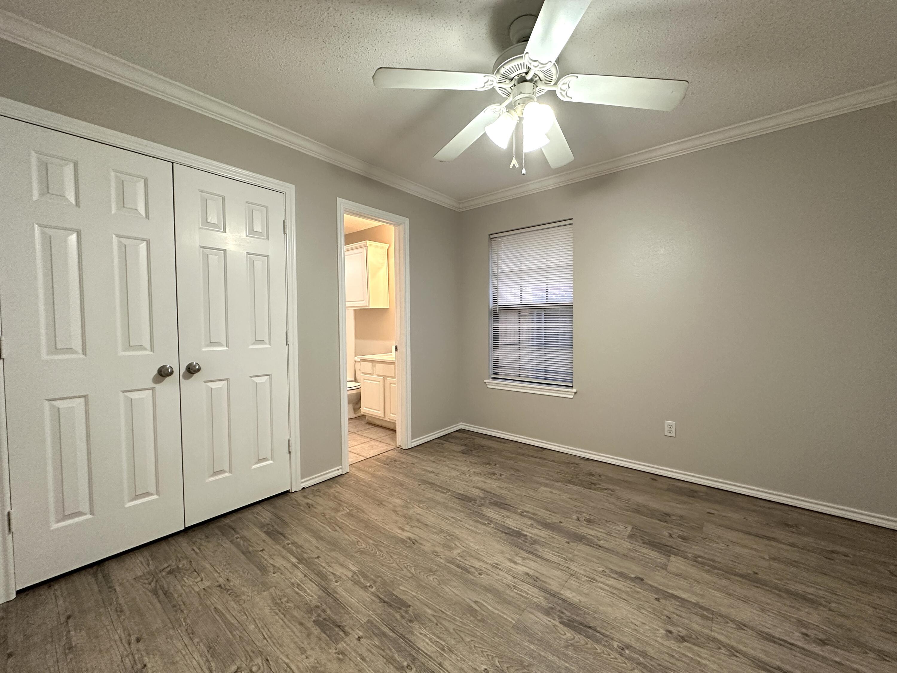 615 North Elkhart Avenue Lubbock, TX 79416 - Photo 7 of 15 an empty room with wooden floor fan and windows