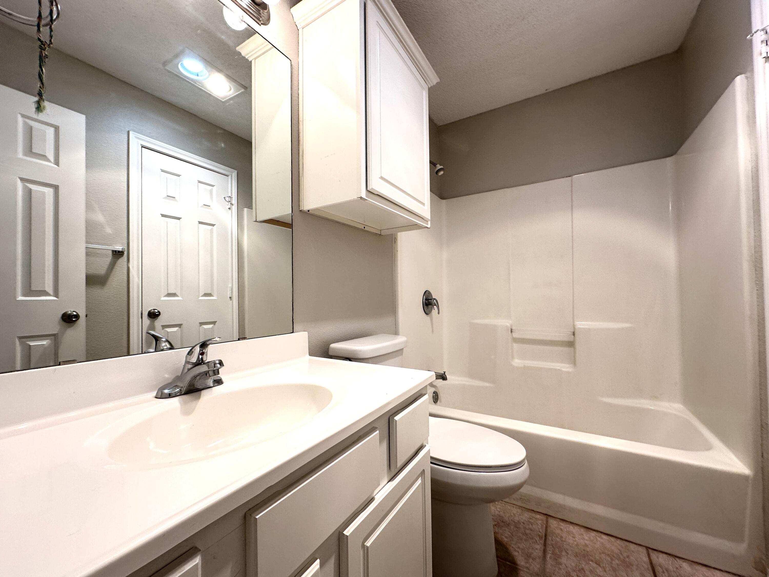 615 North Elkhart Avenue Lubbock, TX 79416 - Photo 9 of 15 a bathroom with a sink a toilet and shower
