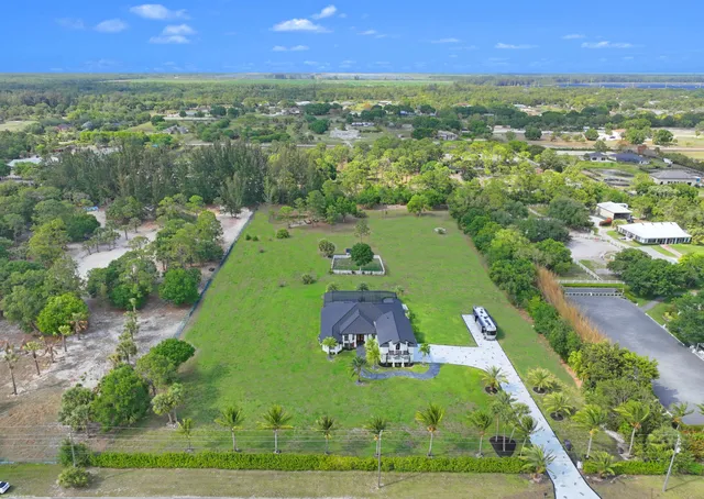 an aerial view of residential houses with outdoor space and trees