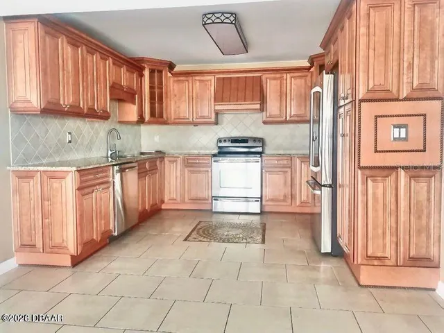 a kitchen with stainless steel appliances granite countertop a stove a sink and a refrigerator