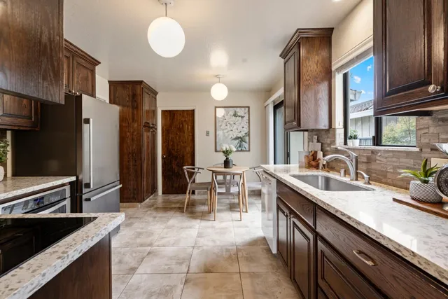 a kitchen with stainless steel appliances granite countertop a sink stove and refrigerator