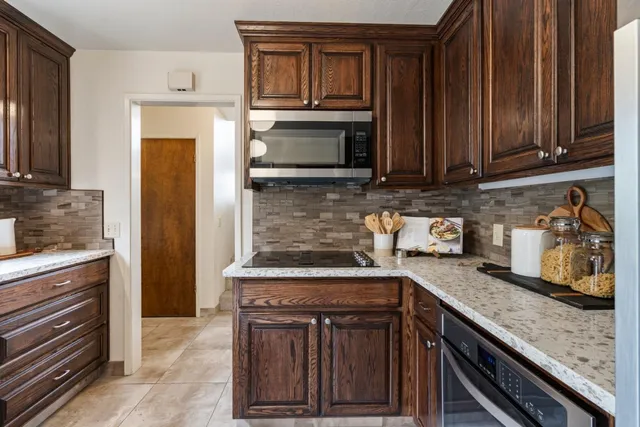 a kitchen with granite countertop a stove and a microwave
