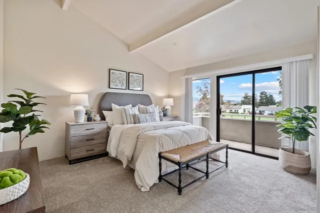 a spacious bedroom with a bed and a potted plant