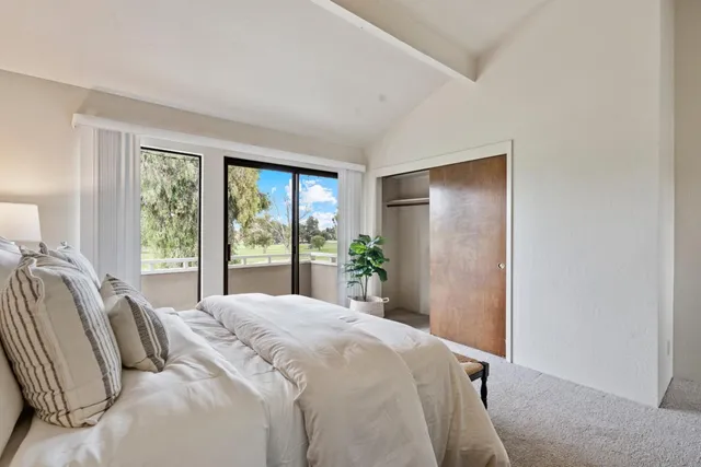 a bedroom with a bed and a large window