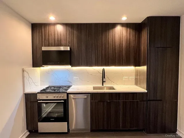 a kitchen with kitchen island a sink and a stove with wooden floor