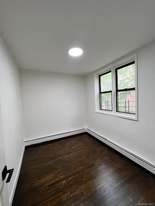 55-30 99th Street, Unit 3F Queens, NY 11368 - Photo 4 of 8 wooden floor in an empty room with a window