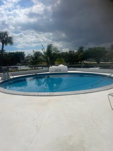 a view of swimming pool with outdoor seating and green space