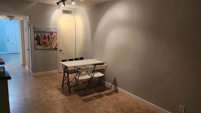 a view of a room with a table and chairs