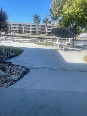 a view of a swimming pool with a lawn chairs under an umbrella