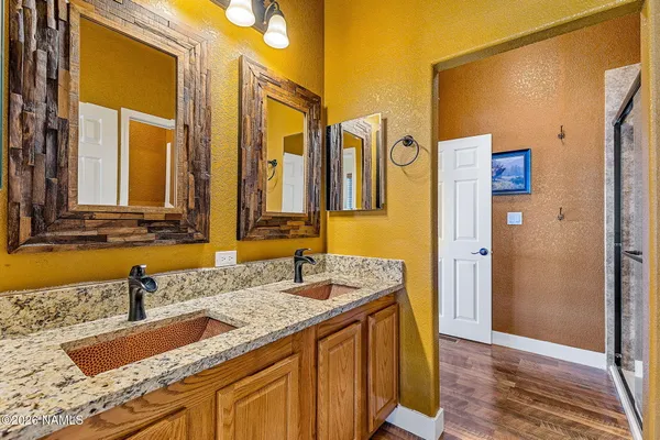a bathroom with a granite countertop double vanity sink and a mirror