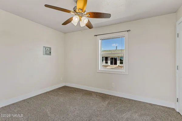 an empty room with a window and a fan