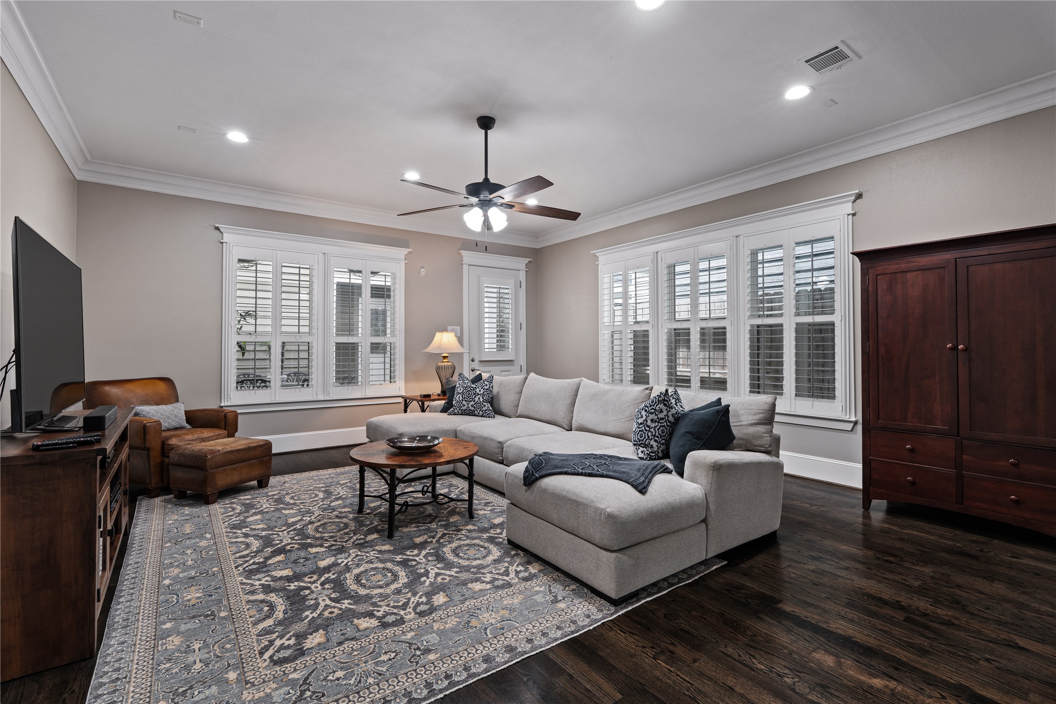 422 West 26th Street Houston, TX 77008 - Photo 15 of 39 The massive living room serves as the ultimate gathering spot, featuring a new ceiling fan and a wall of windows finished with plantation shutters.