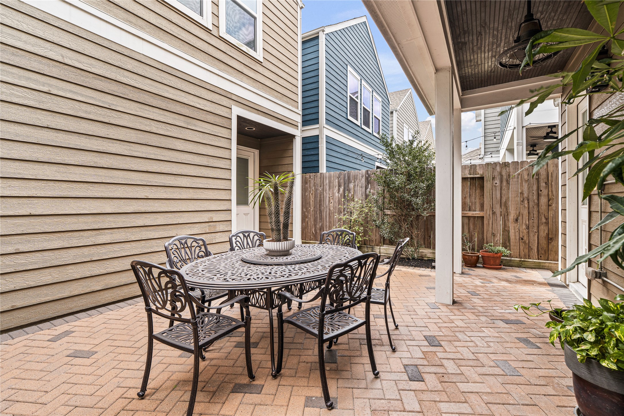422 West 26th Street Houston, TX 77008 - Photo 2 of 39 The private backyard serves as a sophisticated extension of the home, featuring a massive brick-paved patio that connects the main residence to the detached garage apartment.