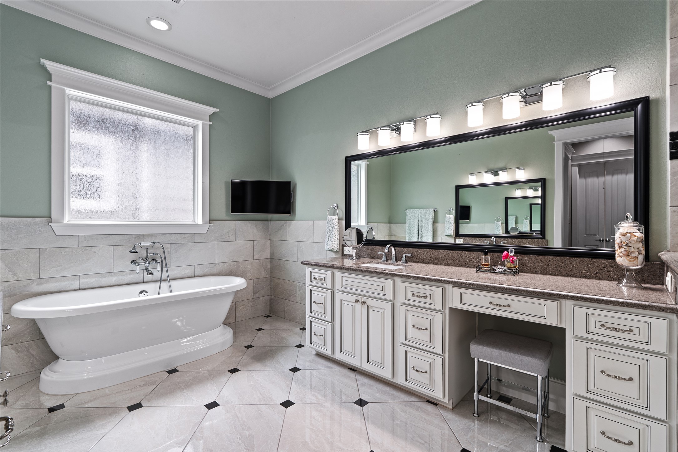 422 West 26th Street Houston, TX 77008 - Photo 22 of 39 This spa-like space offers dual vanities with granite countertops, a dedicated makeup station, and a wall-mounted TV for ultimate relaxation.