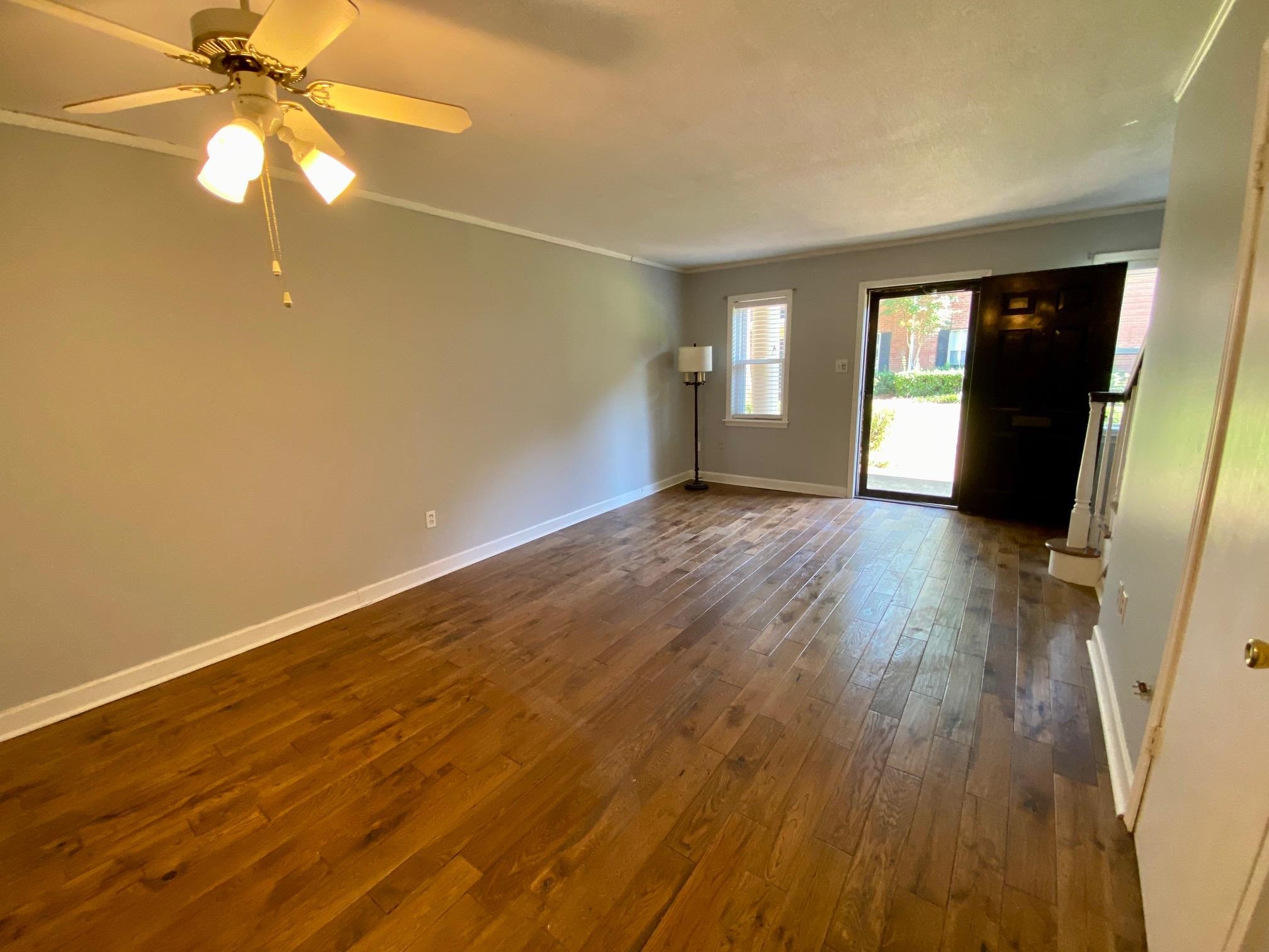 5700 Quince Road, Unit 4 Memphis, TN 38119 - Photo 3 of 16 an empty room with wooden floor fan and windows