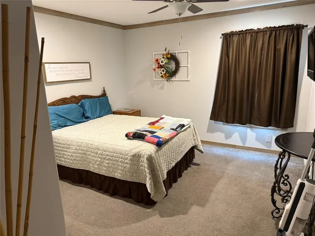 a bedroom with a bed and painting on the wall