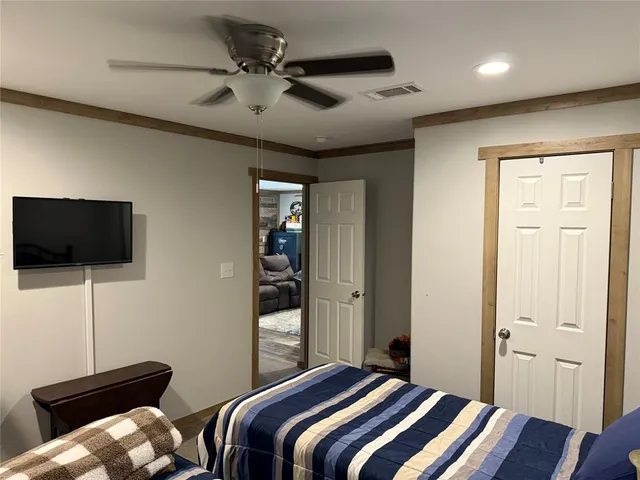 a bedroom with bed and a flat screen tv