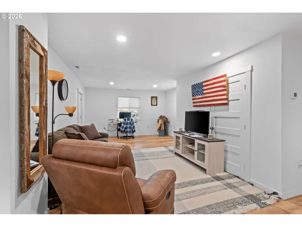a living room with furniture a flat screen tv and kitchen view
