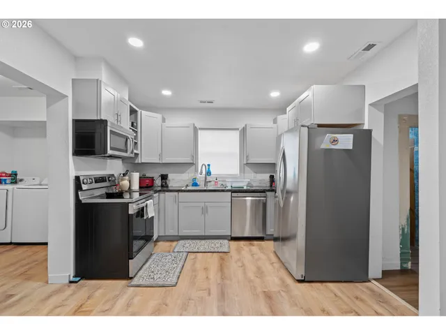 a kitchen with a refrigerator and a stove top oven