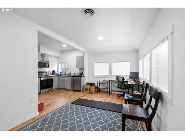 a living room with furniture and a open kitchen view