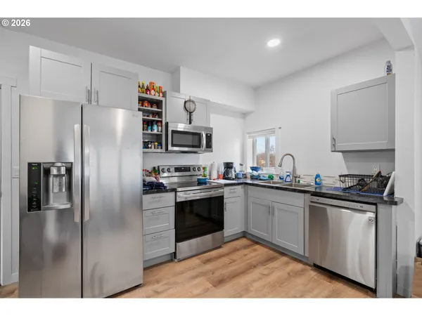 a kitchen with stainless steel appliances granite countertop a refrigerator a sink a stove a microwave and island