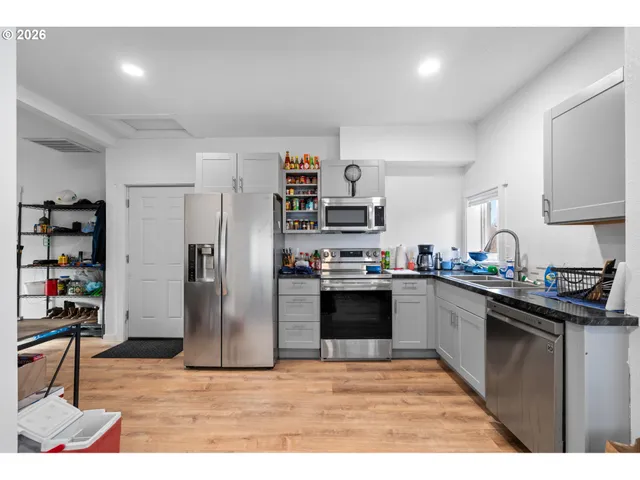 a kitchen with stainless steel appliances granite countertop a refrigerator sink and stove