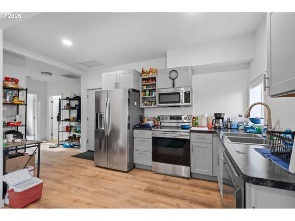 a kitchen with stainless steel appliances kitchen island granite countertop a refrigerator and a stove top oven