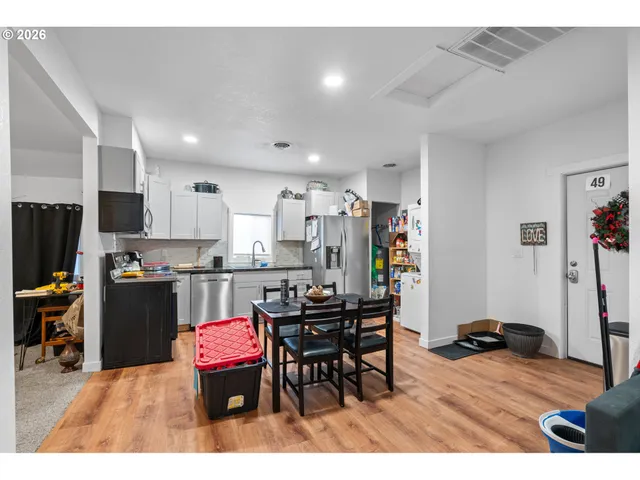 a kitchen with stainless steel appliances kitchen island granite countertop a dining table and chairs
