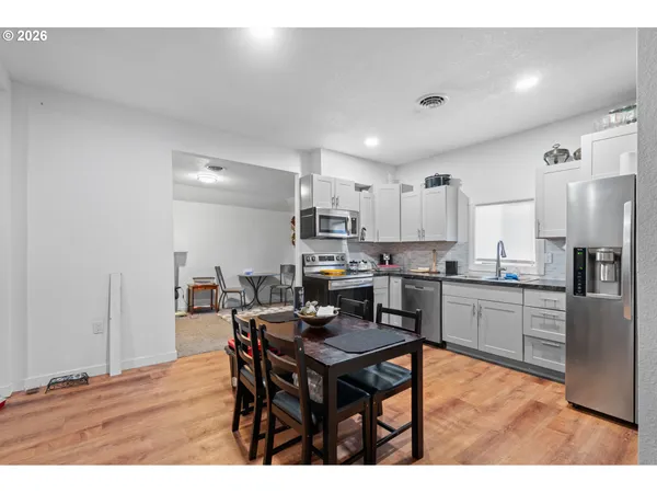 a living room with stainless steel appliances kitchen island granite countertop furniture and a dining table