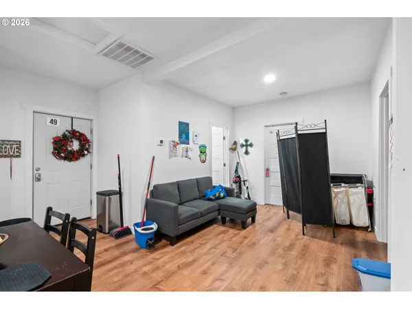 a living room with furniture a flat screen tv and a refrigerator