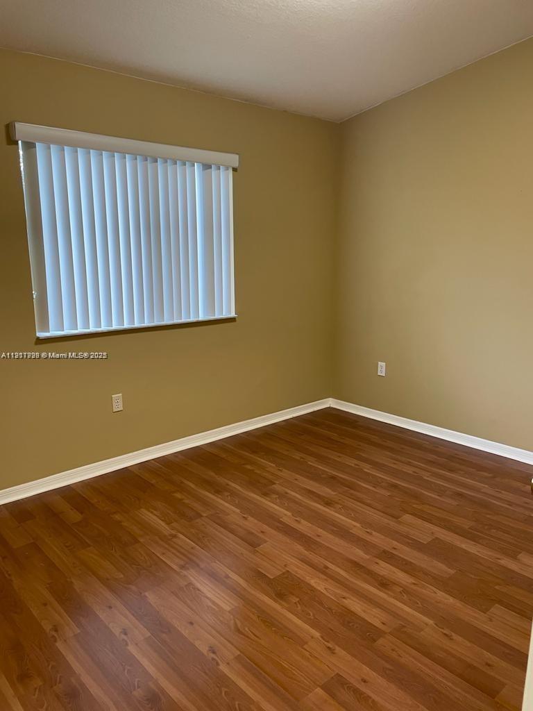 2920 Southeast 13th Road, Unit 20245 Homestead, FL 33035 - Photo 17 of 20 a view of an empty room with wooden floor and a window
