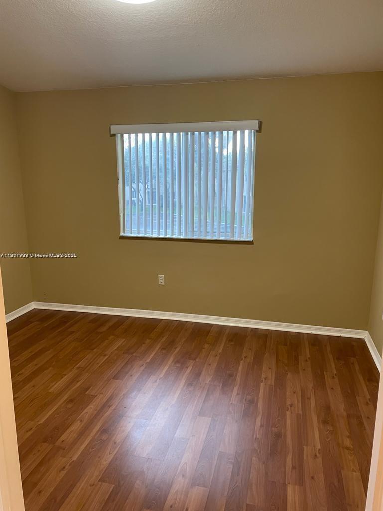 2920 Southeast 13th Road, Unit 20245 Homestead, FL 33035 - Photo 6 of 20 a view of an empty room with wooden floor and a window
