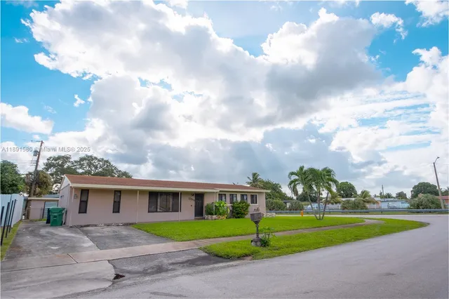 a view of a house with a big yard and a large tree