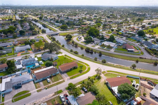 an aerial view of residential houses with outdoor space and parking