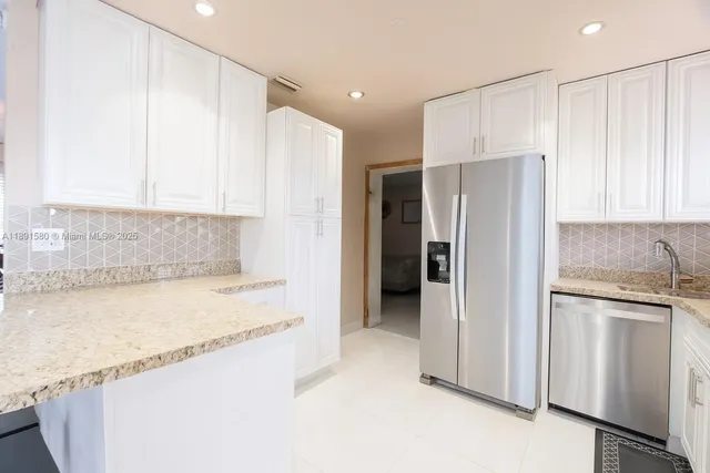 a kitchen with stainless steel appliances granite countertop a refrigerator and a sink