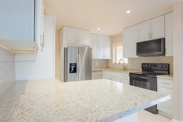 a kitchen with kitchen island wooden cabinets a refrigerator stove and microwave