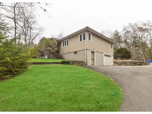 a view of a white house with a big yard and large trees