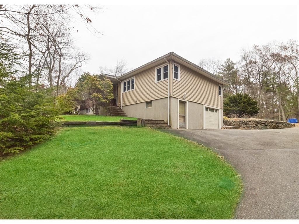 a view of a white house with a big yard and large trees