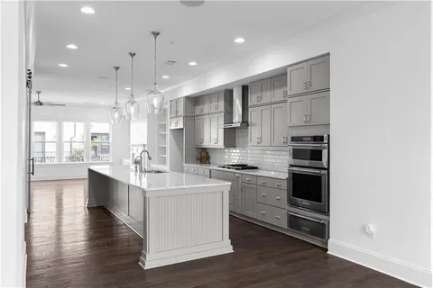 a kitchen with stainless steel appliances kitchen island granite countertop a stove and a sink