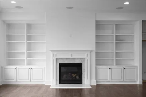 a living room with a fireplace cabinet and a fireplace