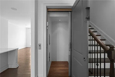 a view of a hallway with a door and stairs