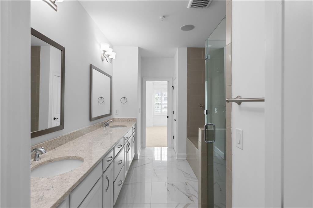 6408 Radiant Trace Atlanta, GA 30328 - Photo 25 of 40 a bathroom with a granite countertop double vanity sink a mirror and a shower
