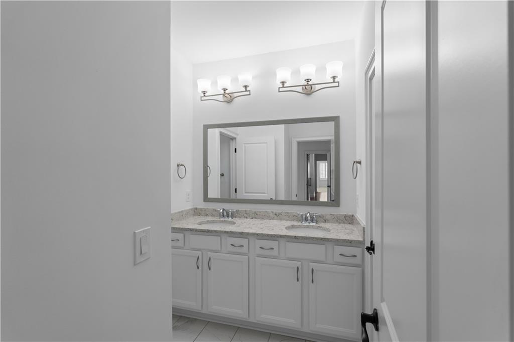 6408 Radiant Trace Atlanta, GA 30328 - Photo 29 of 40 a bathroom with a sink and a mirror