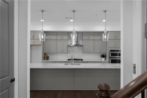 a kitchen with a refrigerator and white cabinets