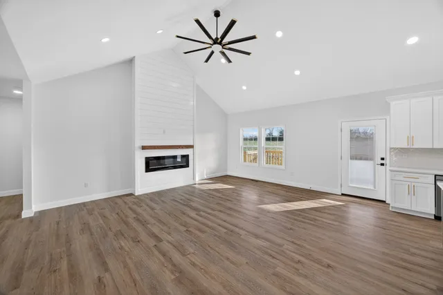 wooden floor in an empty room with a kitchen