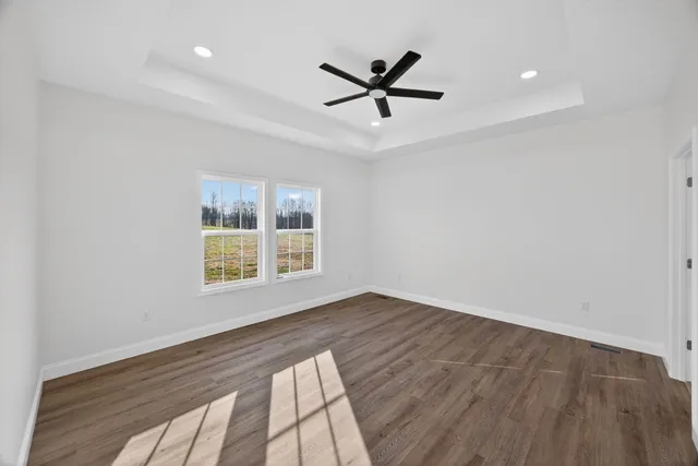 a view of a livingroom with a ceiling fan and wooden floor