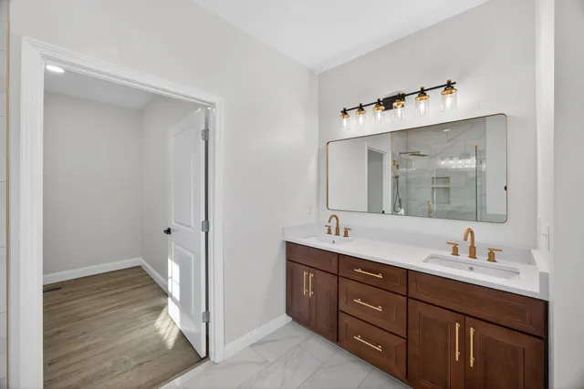 a en suite bathroom with a double vanity sink and a mirror