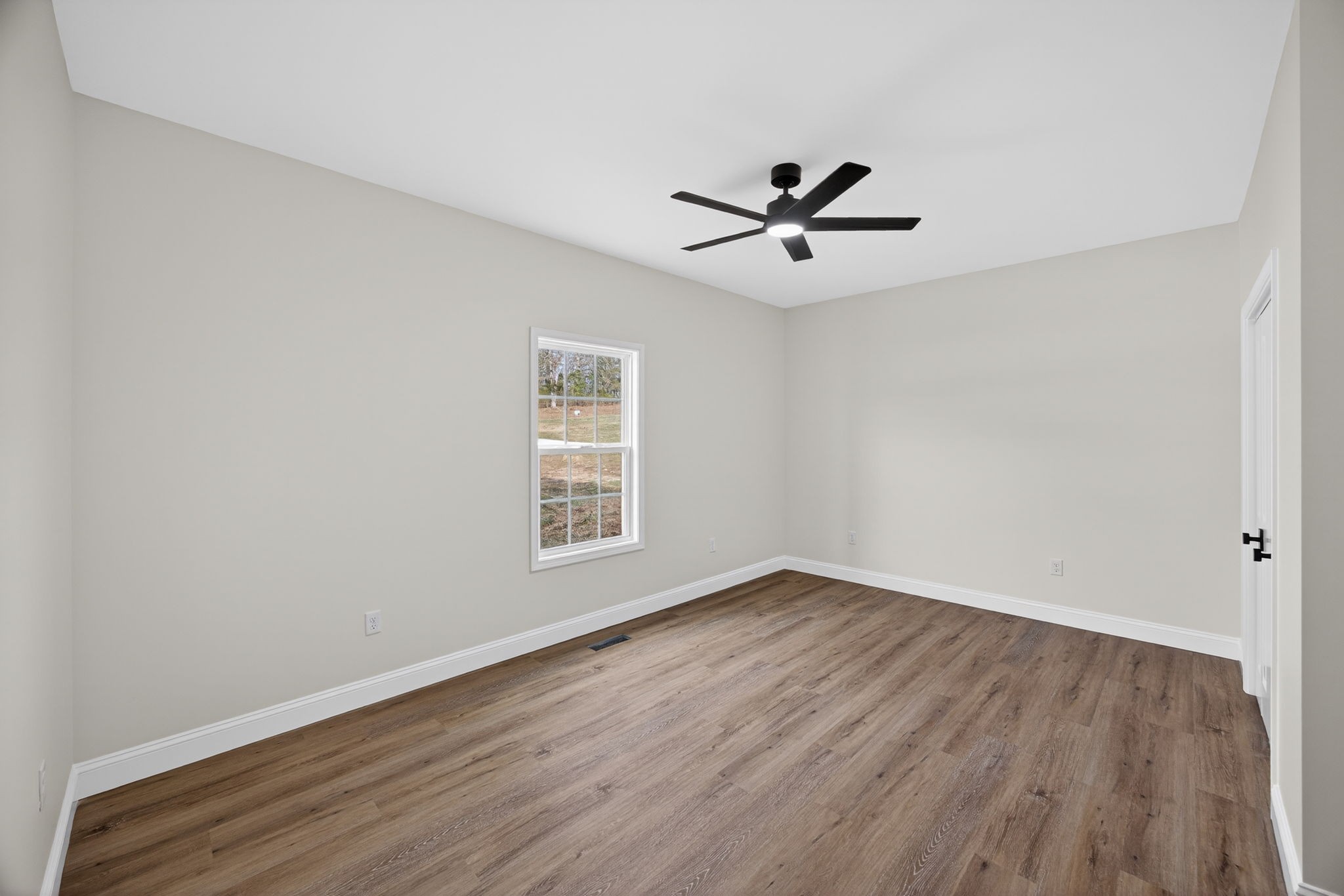 6572 Thomas Twin Oaks Road Baxter, TN 38544 - Photo 18 of 30 an empty room with wooden floor ceiling fan and window
