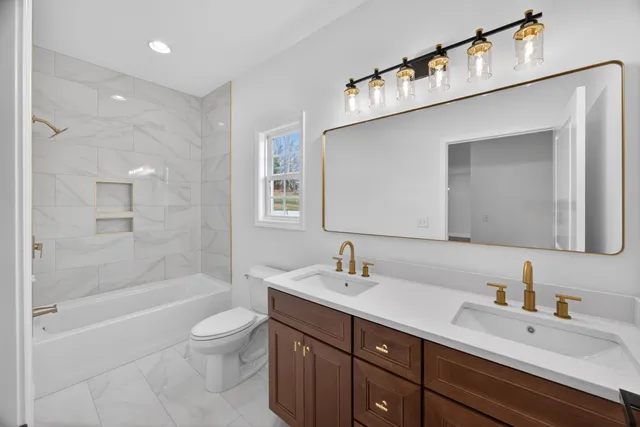 a bathroom with a sink a toilet and shower